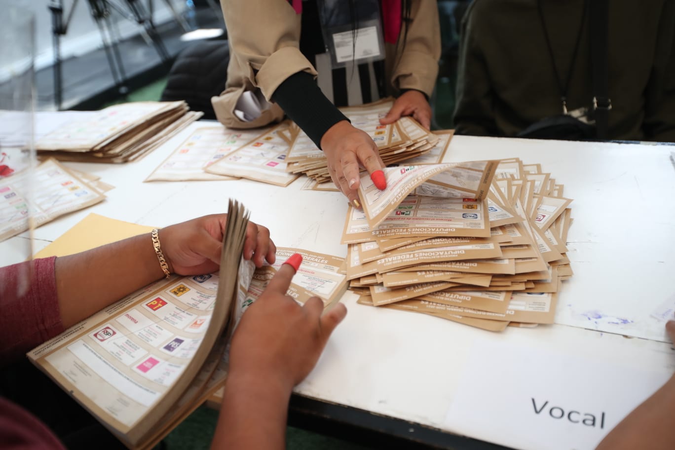 Personas funcionarias de casilla contando boletas electorales