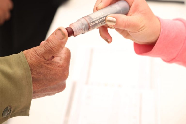 Ciudadano siendo marcado con el liquido indeleble después de ejercer su voto