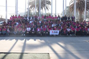 Integrantes del INE posando para fotografía con pancartas en explanada