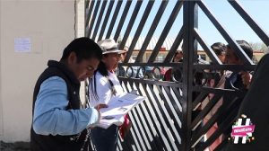 Integrantes del INE entrevistando a personas detrás de una reja