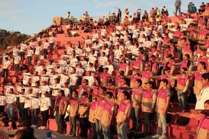 Integrantes del INE formados al aire libre estirando su brazo derecho