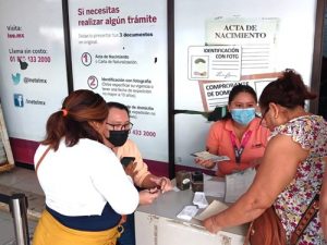 Dos integrantes del INE atendiendo a dos ciudadanas