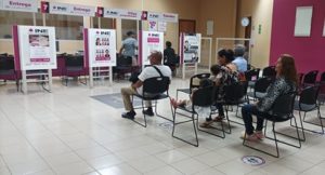 Personas sentadas dentro de Módulo de Atención Ciudadana