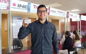 Ciudadano posando con su credencial en Módulo del INE