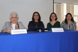 Ponentes del foro sentados detrás de mesa