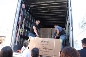 Integrantes del INE descargando material de caja de tráiler