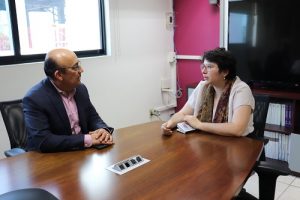 Delegado del INE y consejera política platicando sentados