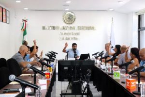 Integrantes del INE Quintana Roo levantando su mano a manera de voto