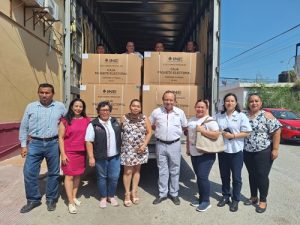 Integrantes del INE posando con material electoral dentro de caja de tráiler