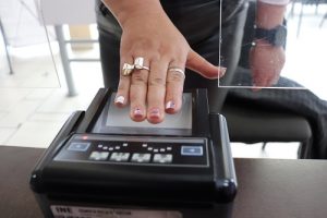 Mano de mujer sobre escáner de huella digital