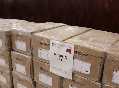 Cajas apiladas con boletas electorales dentro