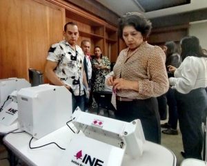 Mujer observando urnas electrónicas