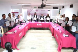 Integrantes del INE Coahuila sosteniendo convenios firmados