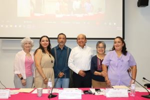 personas que participaron en el foro de pie frente a una mesa