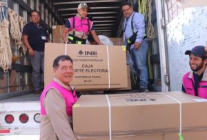 Hombres descargando cajas con material electoral de camión