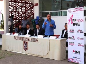 Hombres y mujeres detrás de un podio aplaudiendo