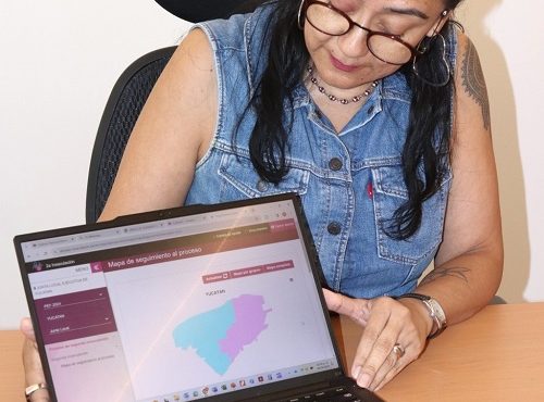 Mujer mostrando pantalla de laptop