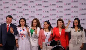 Candidato y candidatas al senado de pie posando para fotografía