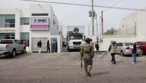 Elementos de la Marina e integrantes del INE observando tráiler con boletas electorales