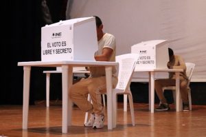 Persona en prisión preventiva efectuando su voto