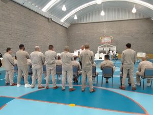 Hombres en prisión preventiva de pie en patio de penitenciaria previo a la votación