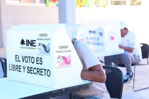 Hombres en prisión preventiva efectuando su voto en casilla