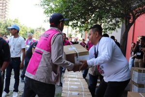 Integrantes del INE cargando cajas con boletas electorales
