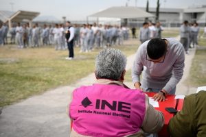 Persona en prisión preventiva votando frente a integrante del INE