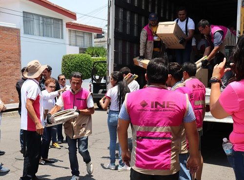 Integrantes del INE descargando cajas de un tráiler