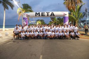 Grupo de personas bajo el marco de Meta, posando para la foto