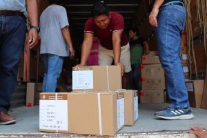 Integrantes del INE Tabasco descargando cajas de trailer