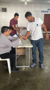 Integrante del INE marcando el pulgar de hombre en prisión preventiva