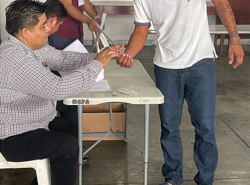 Integrante del INE marcando el pulgar de hombre en prisión preventiva