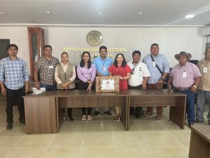 Integrantes del INE con material electoral dentro de oficina posando para foto