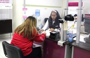 Integrante del INE atendiendo a mujer en MAC