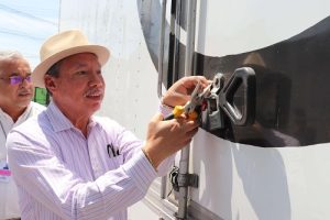 Hombre con sombrero abriendo cerradura de caja de tráiler