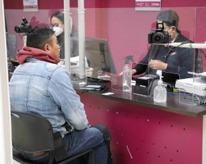 Hombre sentado siendo atendido por integrante del INE en Tlaxcala