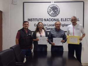 Cuatro personas del INE Tamaulipas de pie en una oficina