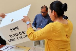 Dos personas armando una urna para votar