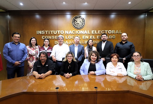 personas de pie y sentadas frente a una mesa color café