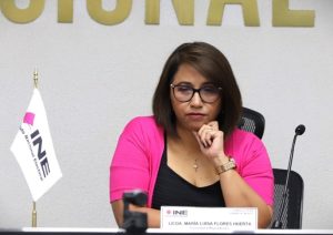 Mujer con lentes con su mano izquierda sobre su barbilla