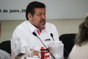 Hombre de barba de candado sentado hablando a micrófono