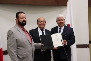 tres hombres de pie mostrando un documento