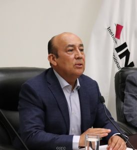 Hombre sentado hablando a micrófono