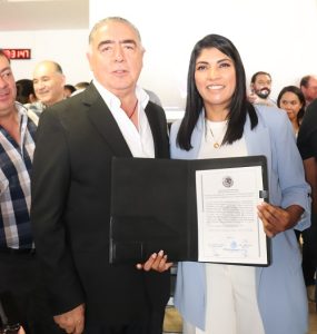 dos personas de pie mostrando un documento