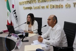 Dos integrantes del INE Tabasco sentados hablando a micrófono