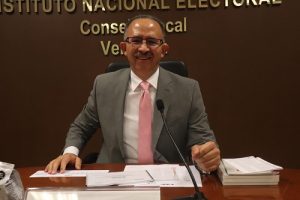 Hombre vistiendo traje sentado y sonriendo