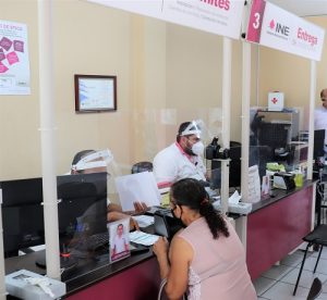 personas con caretas y cubrebocas atendiendo a la ciudadanía