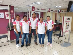 personas de pie con el uniforme del INE