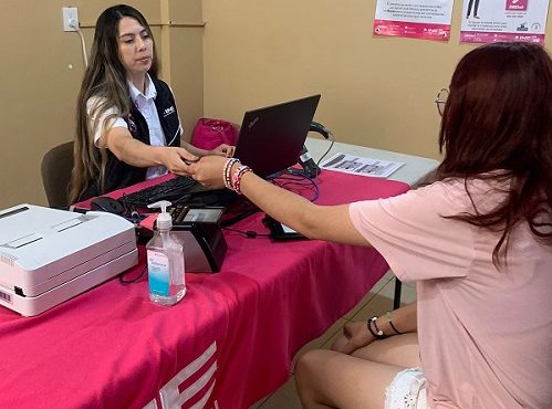 Mujer funcionaria del INE atendiendo a otra mujer